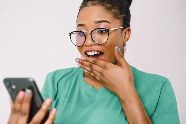 A woman beaming with joy while viewing her RekodUpesi dashboard